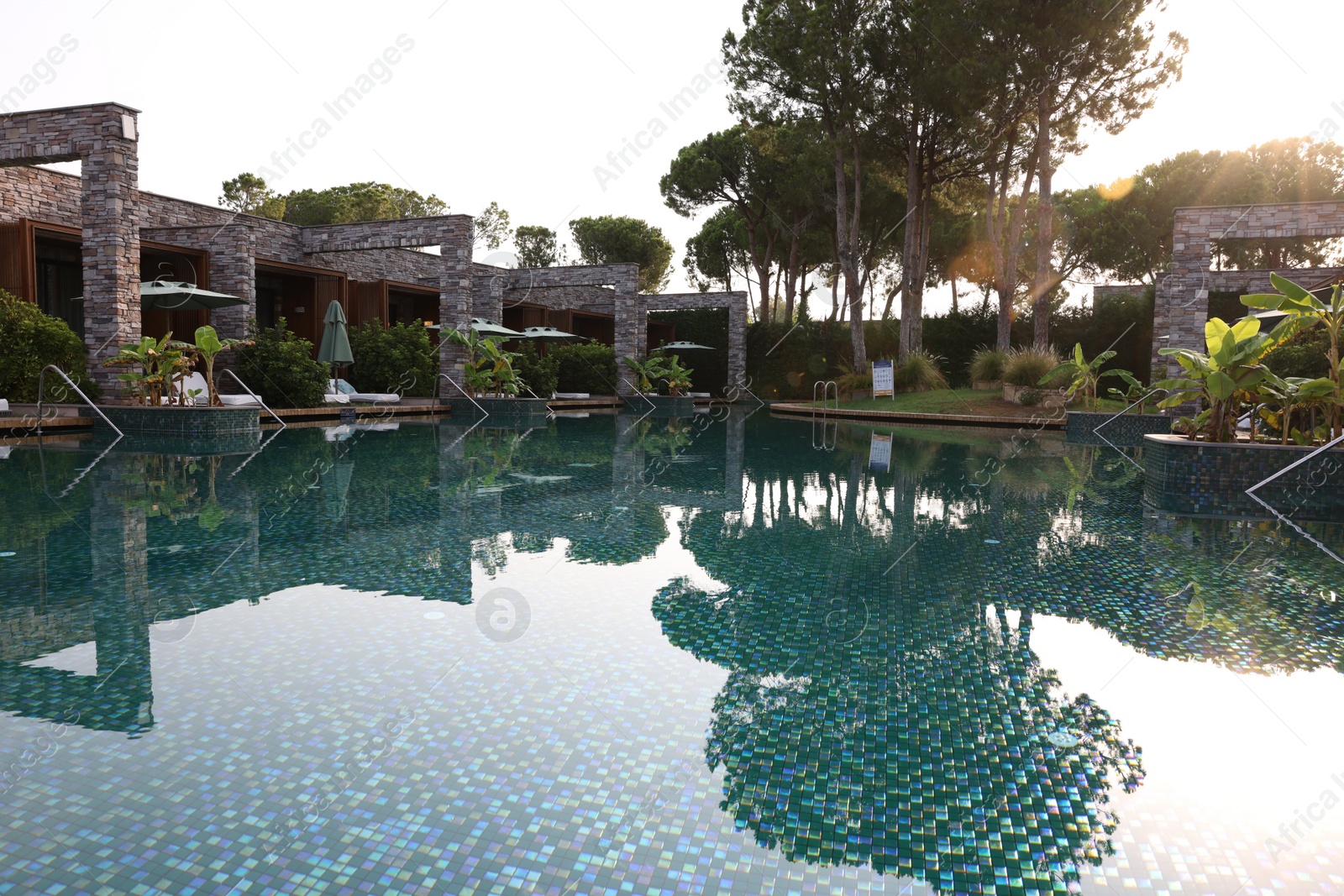 Photo of Outdoor swimming pool with umbrellas and sunbeds at resort