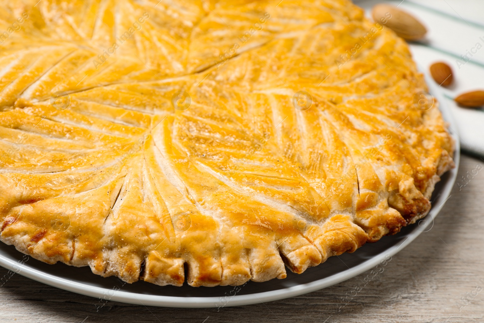 Photo of Traditional galette des rois on white wooden table, closeup