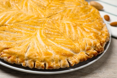 Photo of Traditional galette des rois on white wooden table, closeup