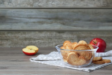 Delicious cookies in glass bowl on wooden table. Space for text