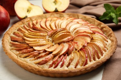Photo of Delicious homemade apple tart on white wooden table