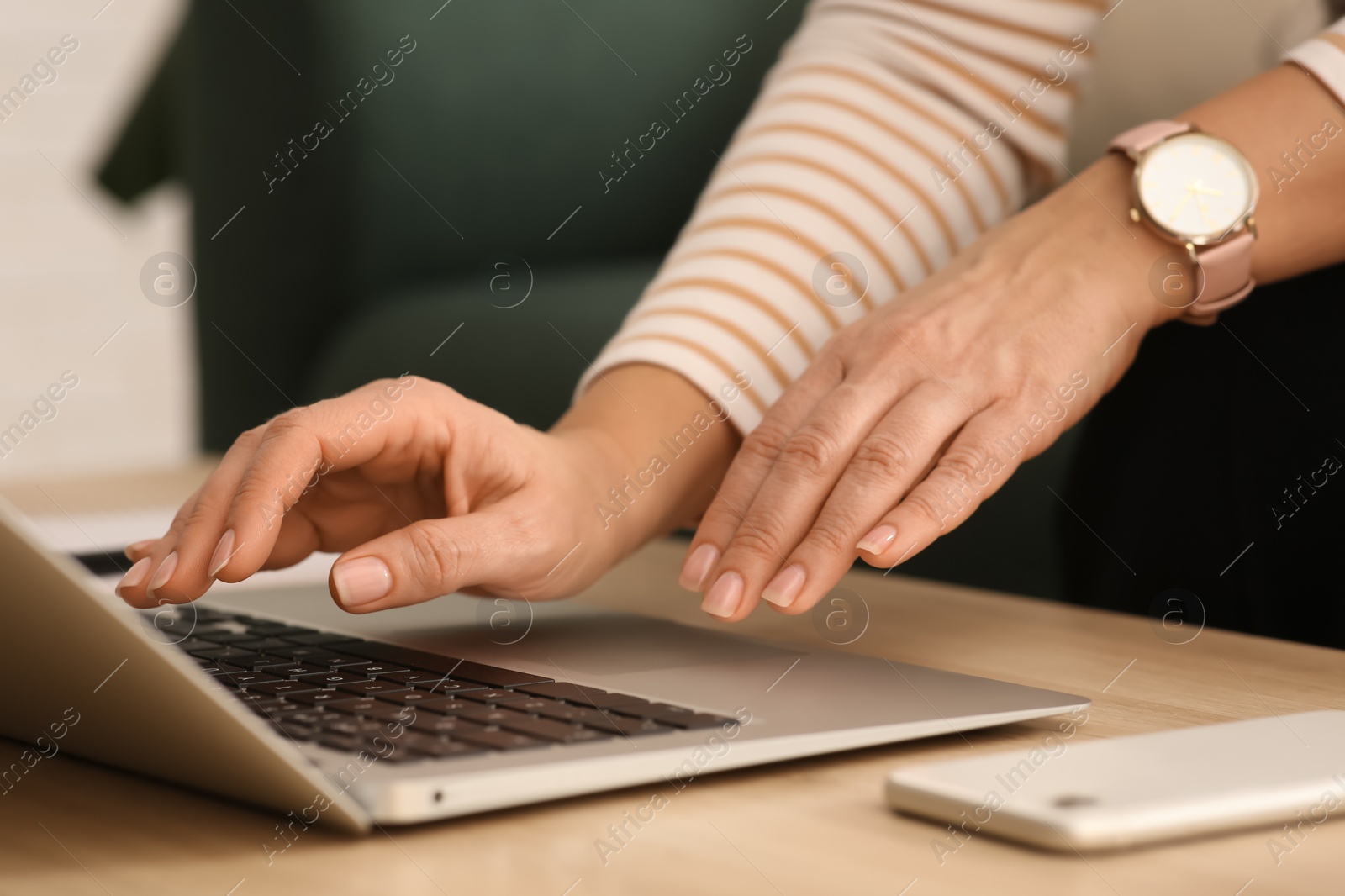 Photo of Woman with modern laptop learning at table indoors, closeup