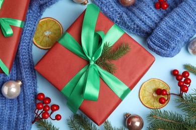 Flat lay composition with red gift box and Christmas decor on light blue background