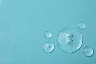 Photo of Samples of cosmetic serum on light blue background, flat lay. Space for text