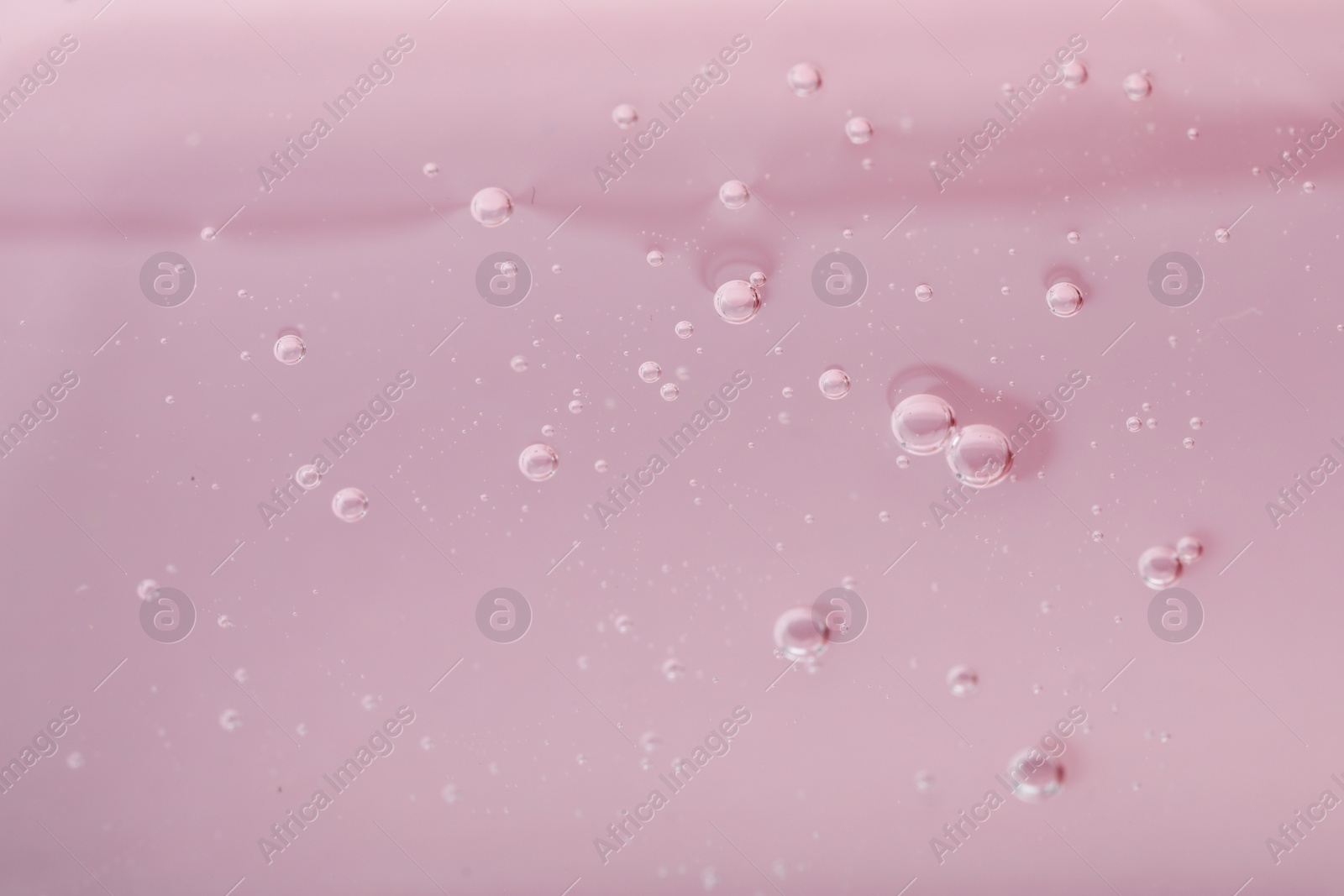 Photo of Pure transparent cosmetic gel on pink background, closeup