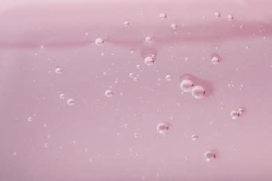 Photo of Pure transparent cosmetic gel on pink background, closeup