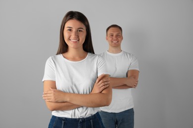 Photo of Portrait of happy young woman and man on light background