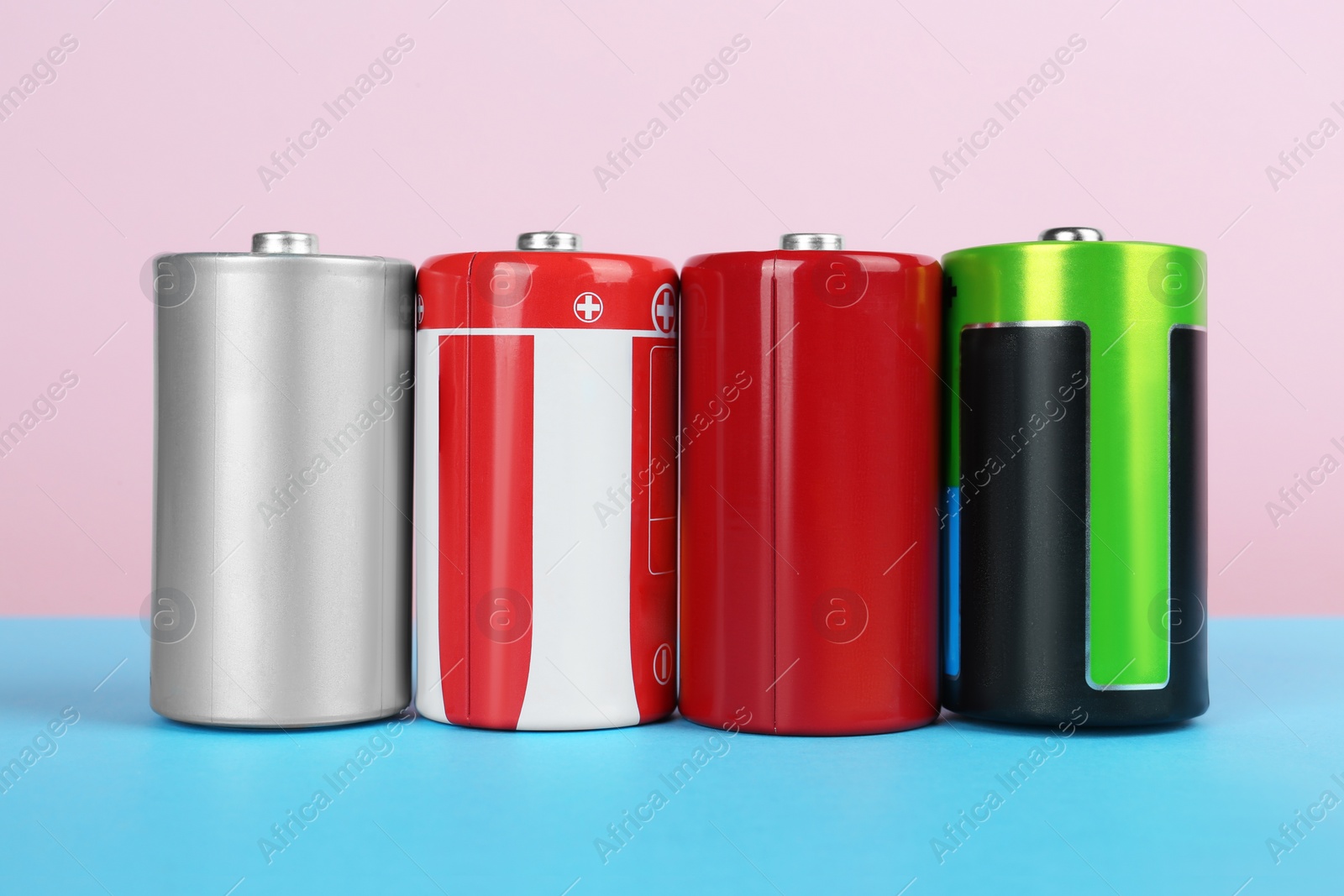 Image of Different new D batteries on color background