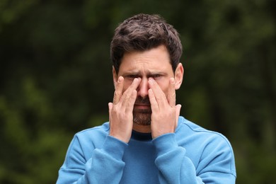 Man suffering from seasonal spring allergy outdoors