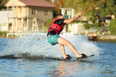 Photo of Man wakeboarding on river. Extreme water sport