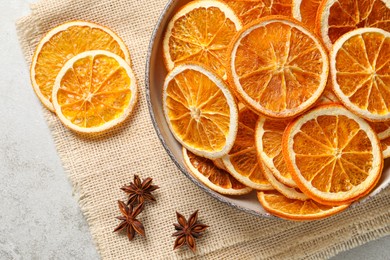 Dry orange slices and anise stars on light table, top view