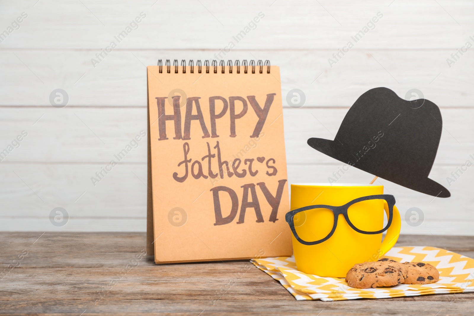 Photo of Composition with notebook, cup and glasses on wooden table. Father's day celebration