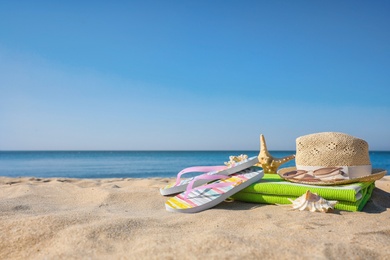 Set with stylish beach accessories on sand near sea