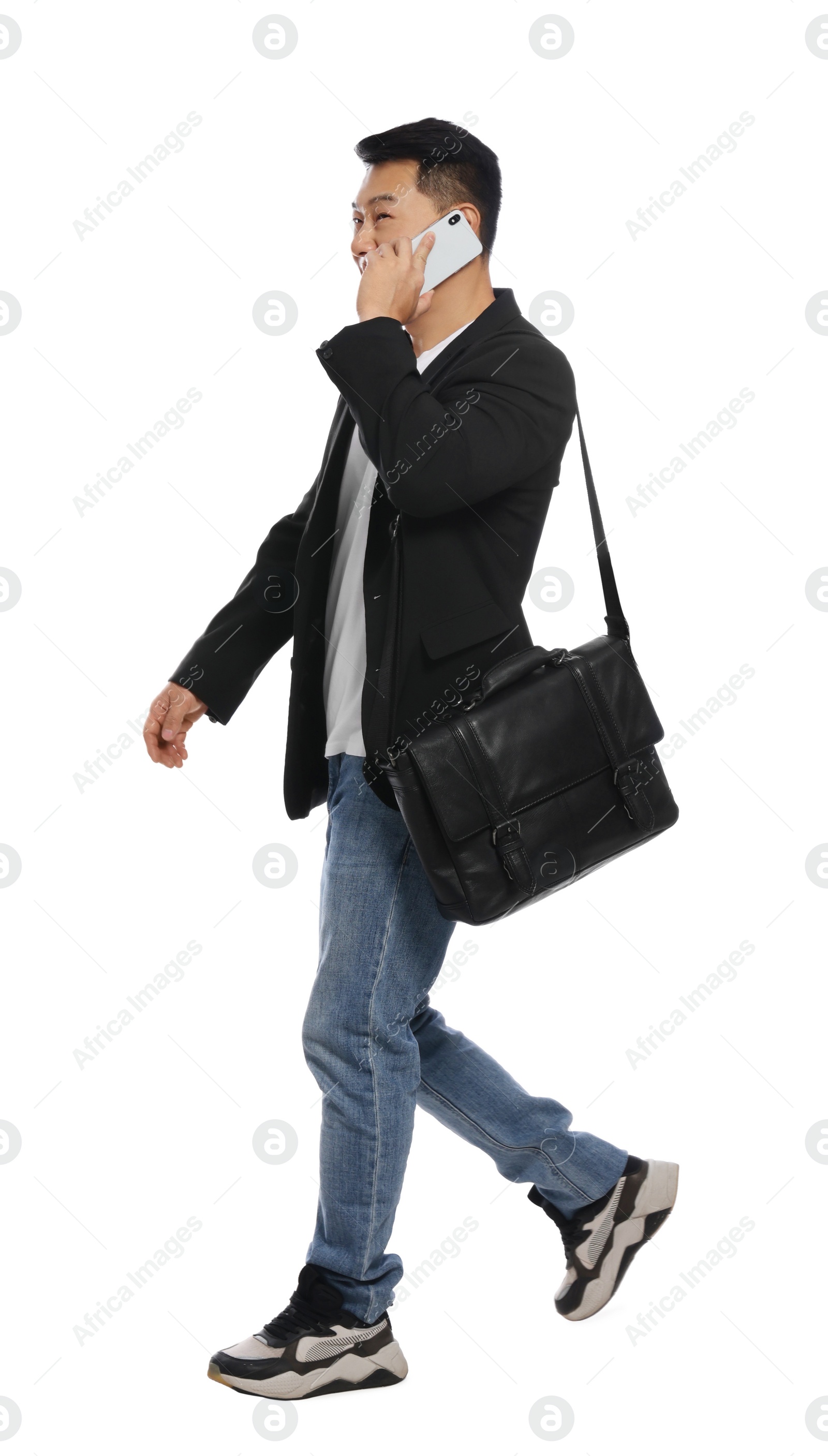 Photo of Man with bag talking on smartphone against white background