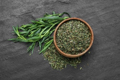 Photo of Dry and fresh tarragon on black textured table, flat lay