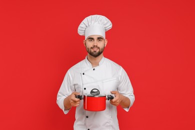 Professional chef with cooking pot on red background