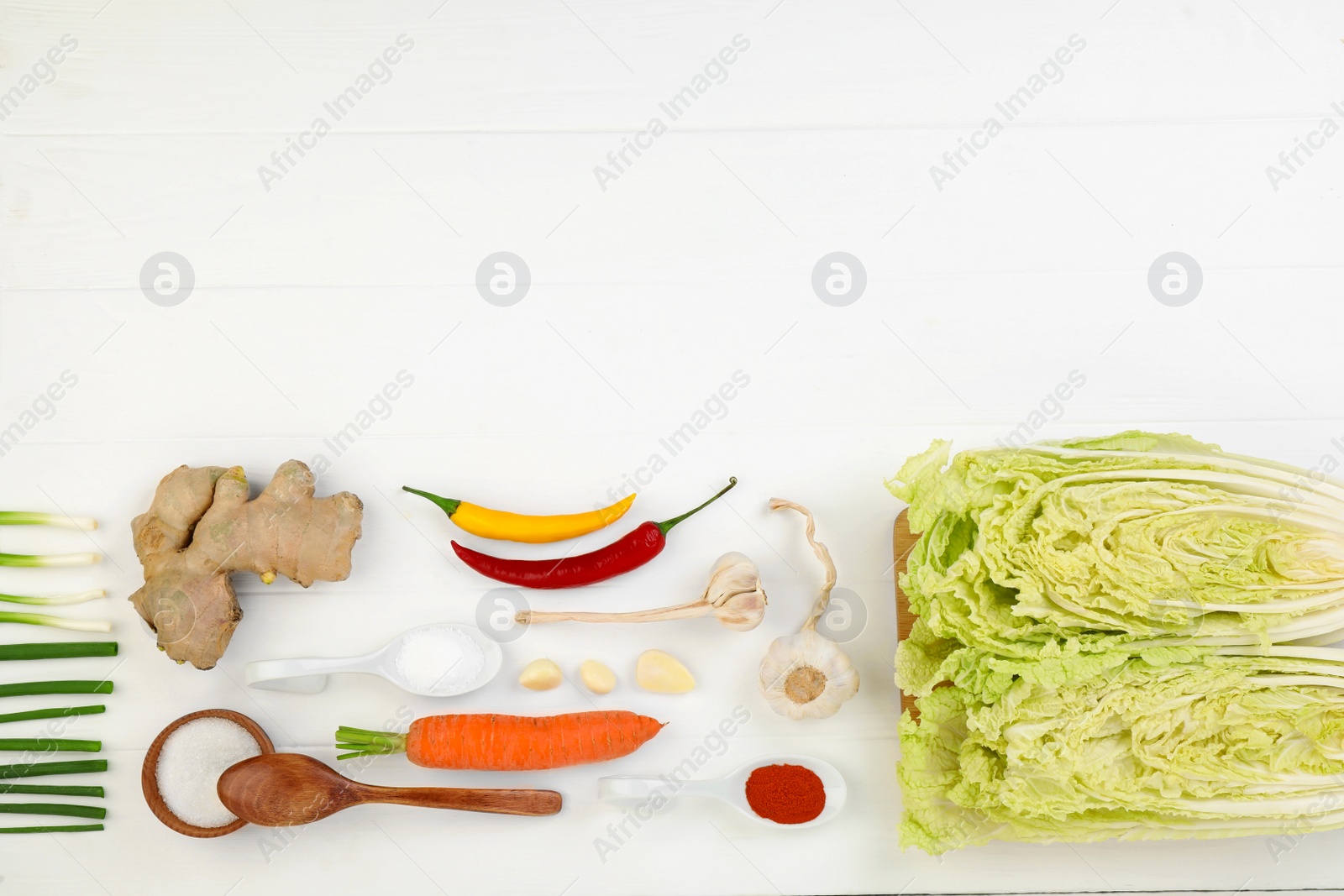 Photo of Flat lay composition with fresh Chinese cabbage and ingredients on white wooden table. Space for text