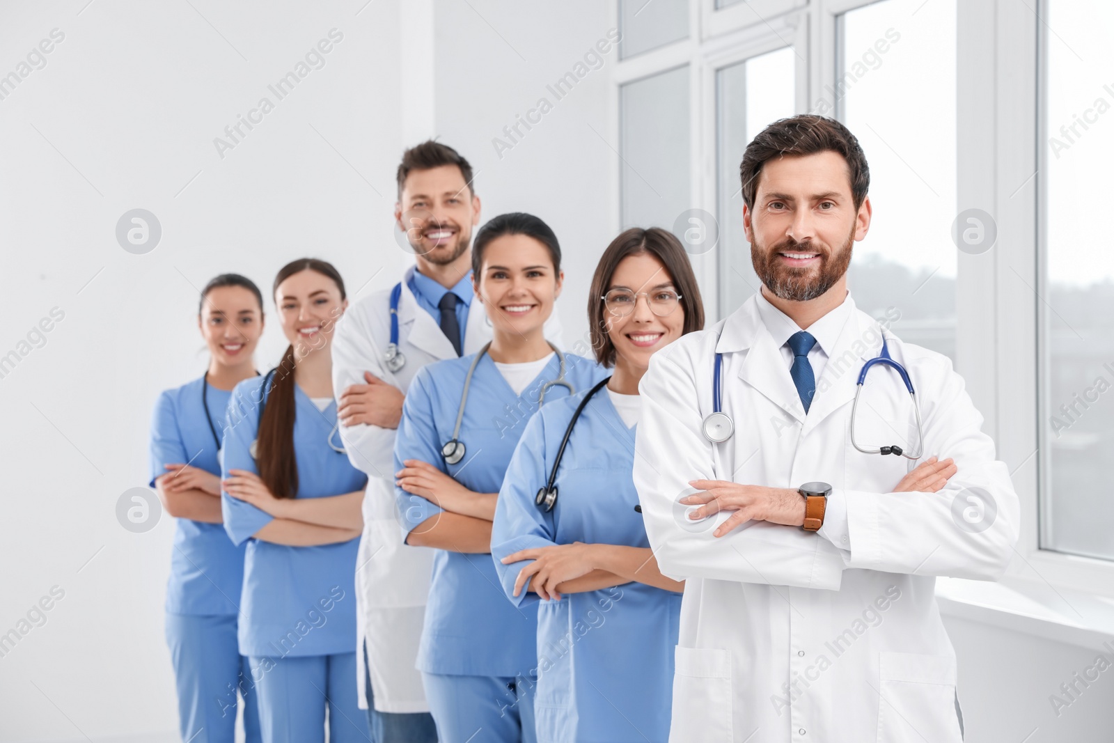 Photo of Team of professional doctors in clinic hallway