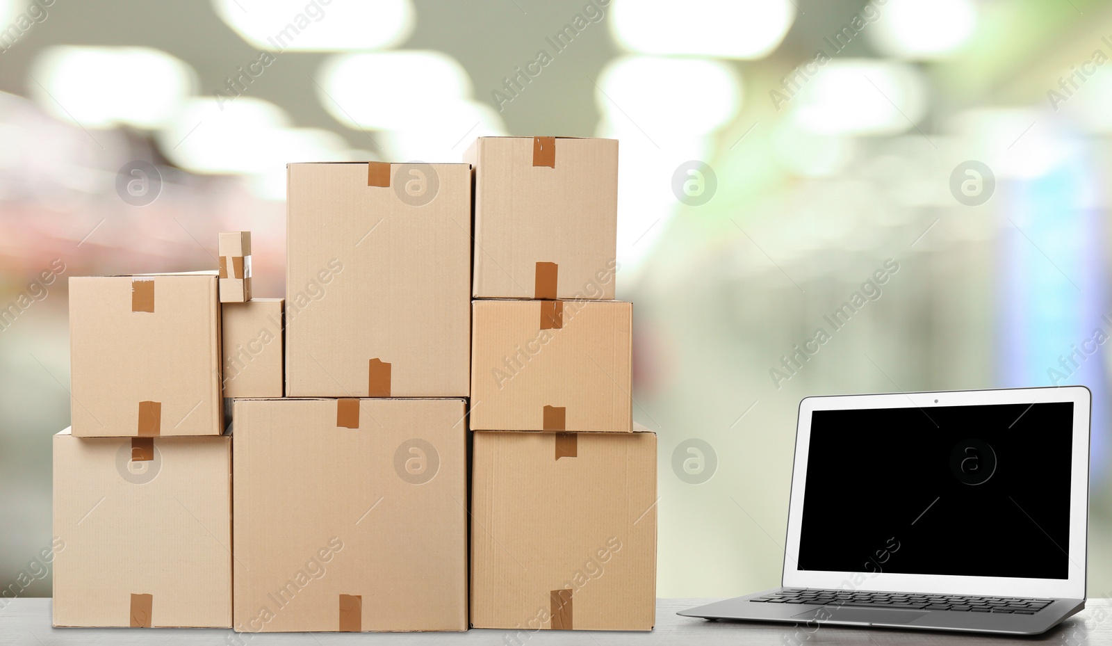 Image of Online selling. Laptop and parcels on table in store