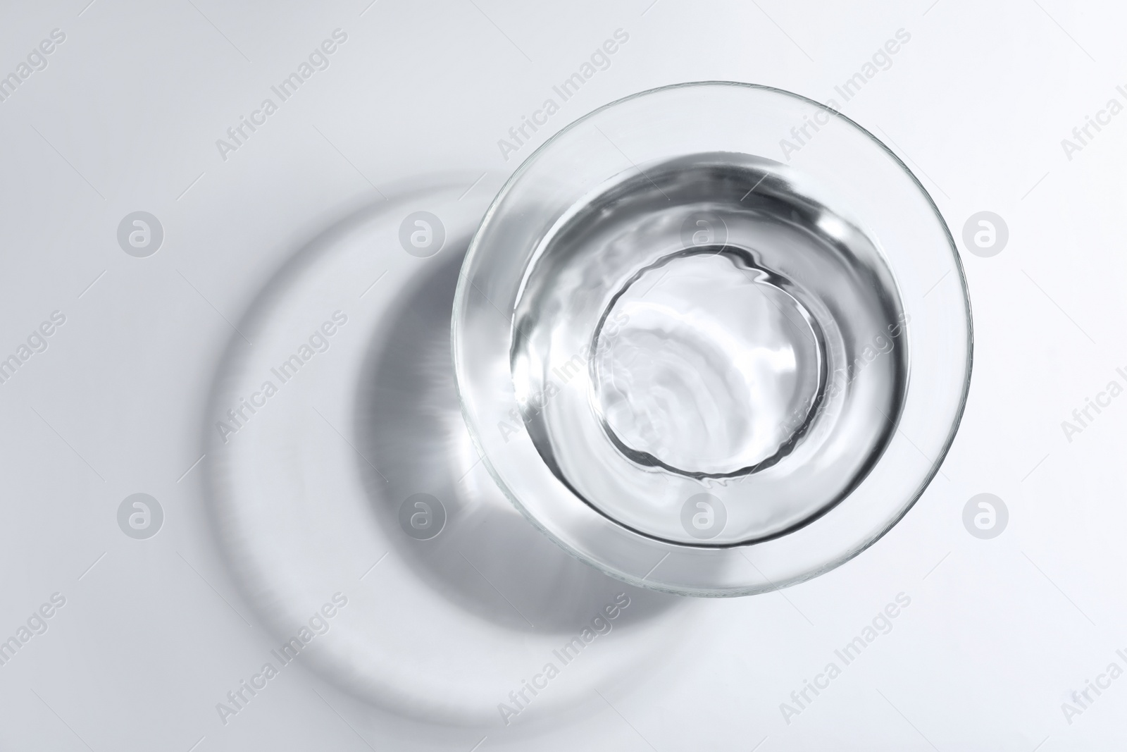 Photo of Glass bowl with water on white background, top view