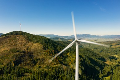 Modern wind turbines in mountains on sunny day. Alternative energy source