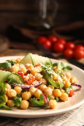Photo of Plate with delicious fresh chickpea salad on table