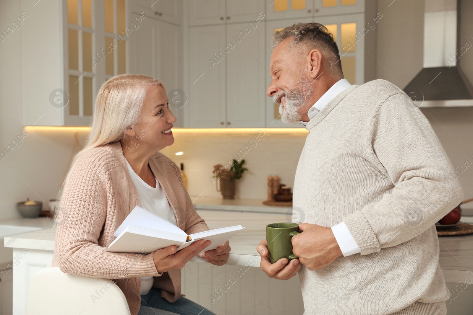 Photo of Happy senior couple spending time together in kitchen