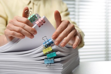 Woman working with documents at table in office, closeup