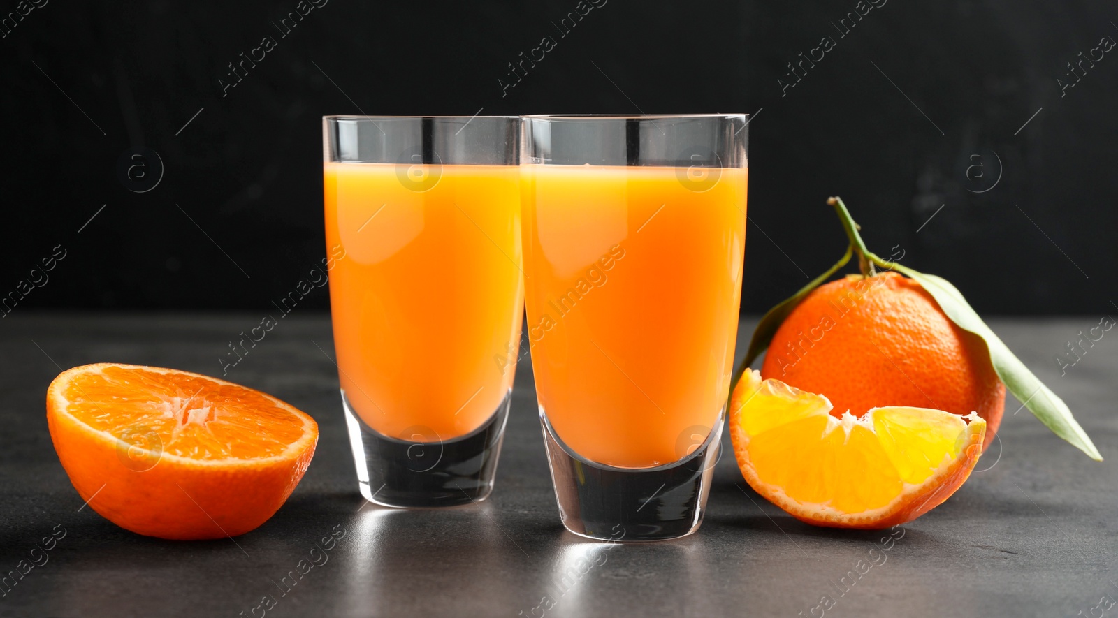 Photo of Delicious tangerine liqueur and fresh fruits on grey table