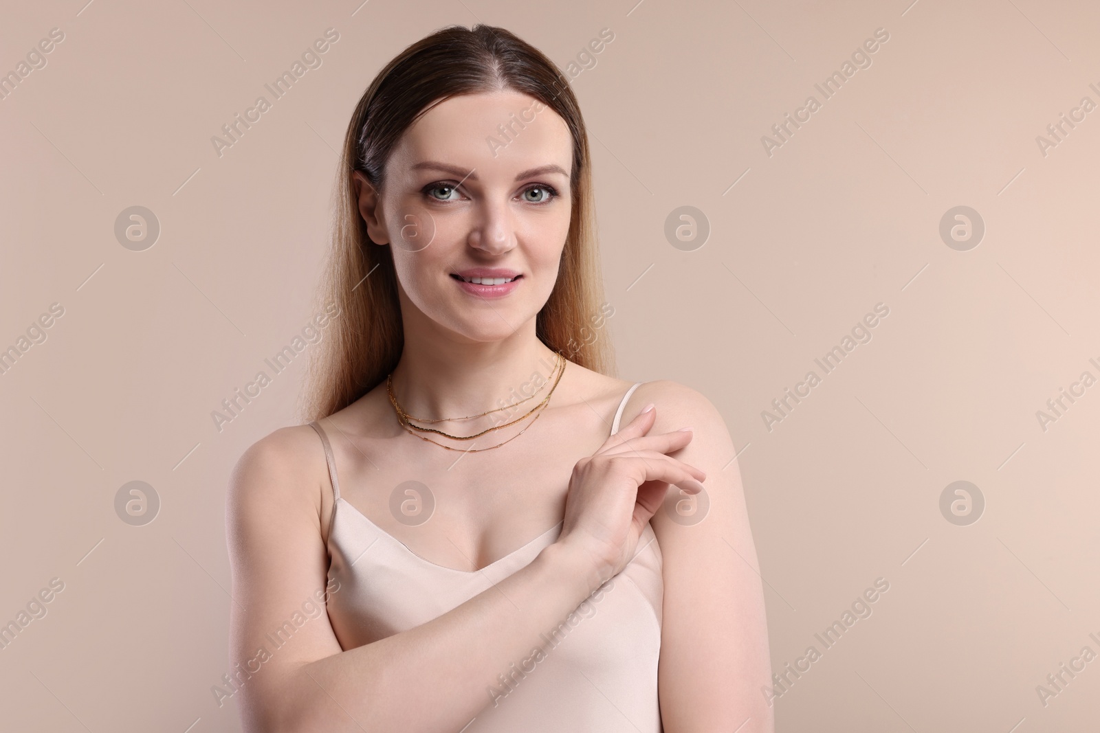 Photo of Beautiful woman with elegant necklace on beige background