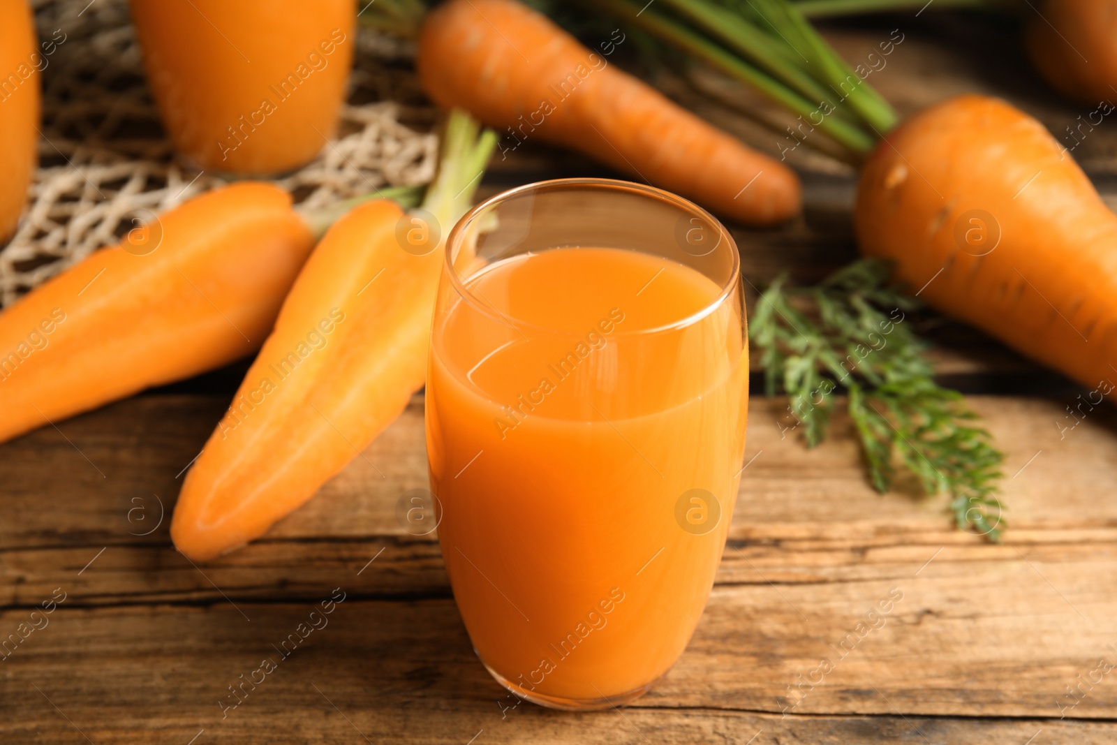 Photo of Freshly made carrot juice on wooden table