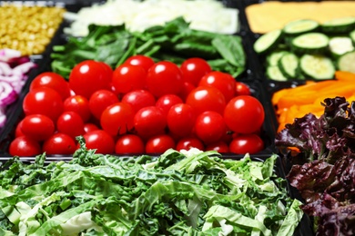 Salad bar with different fresh ingredients as background, closeup