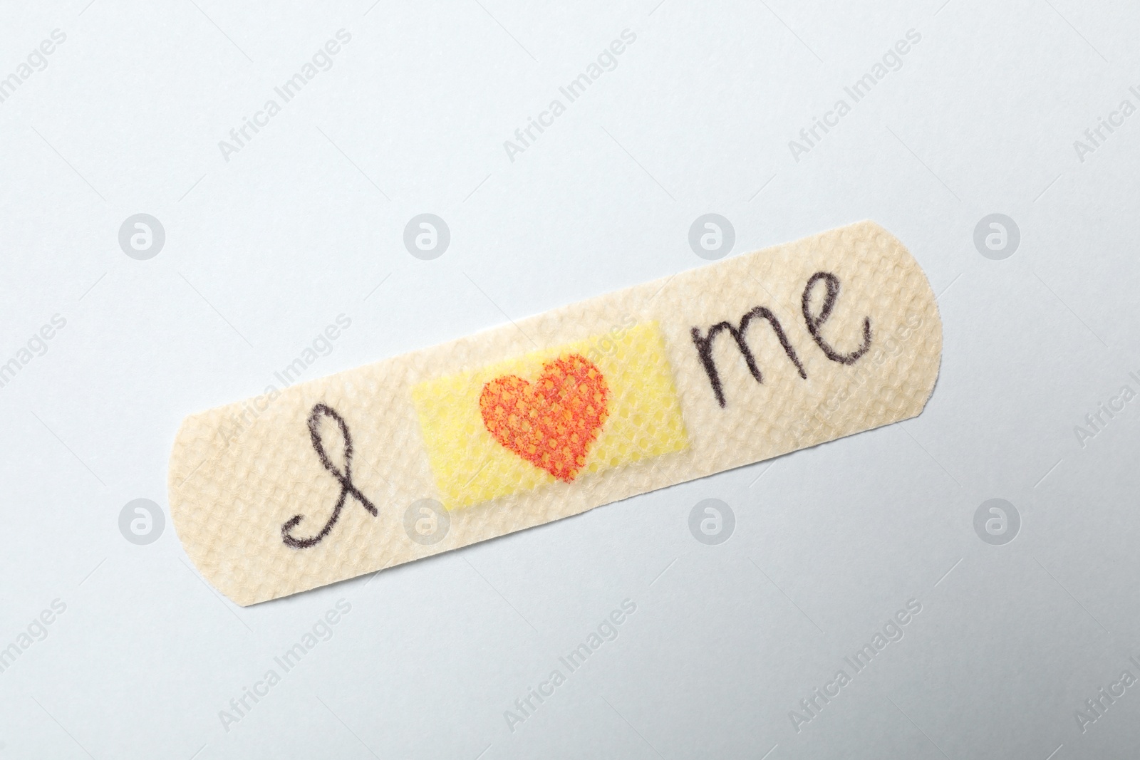 Photo of Sticking plaster with phrase I Love Me on white background, top view