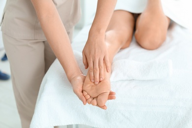Woman receiving foot massage in wellness center, closeup
