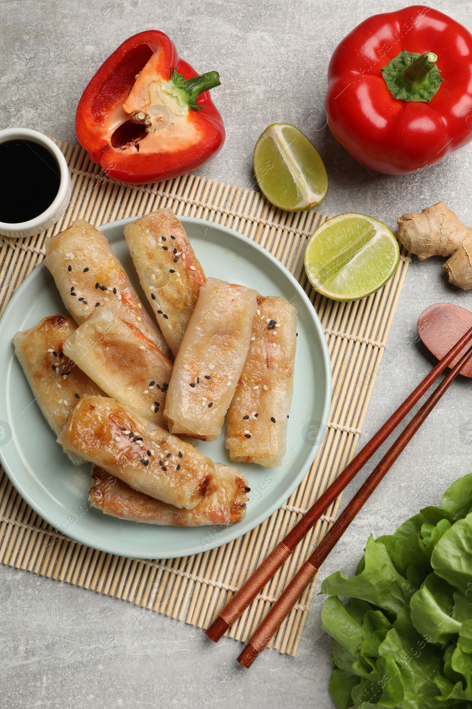 Photo of Tasty fried spring rolls served on gray table, flat lay