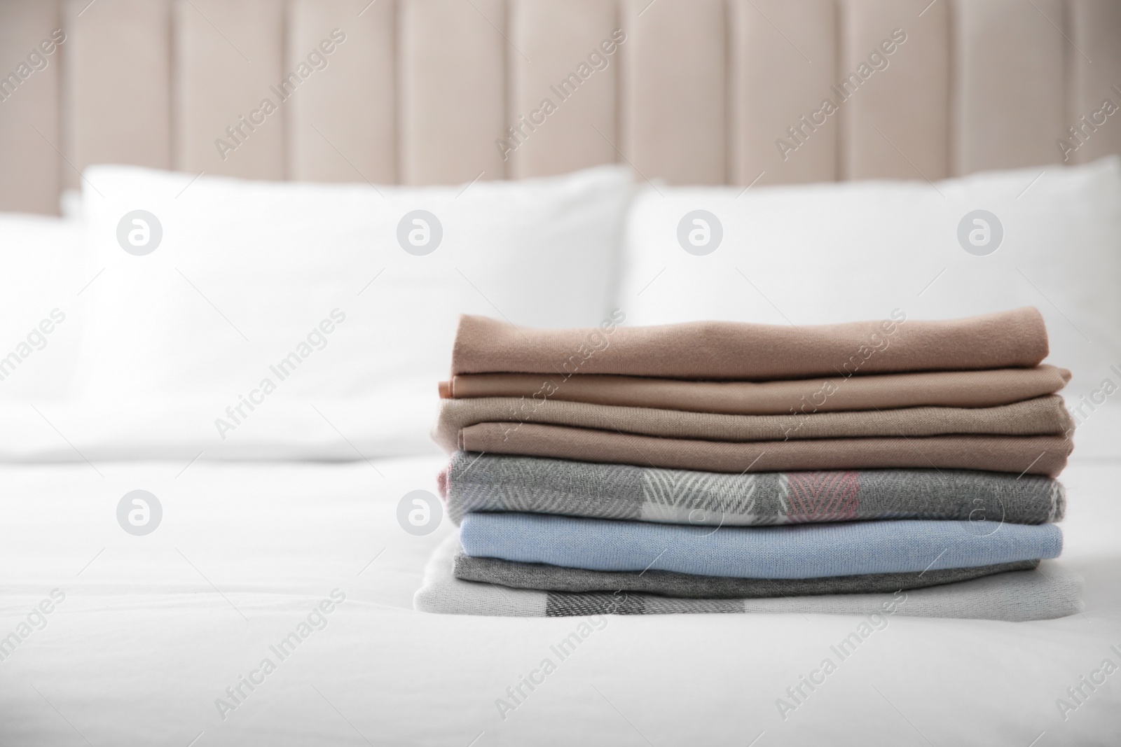 Photo of Stack of folded cashmere clothes on bed