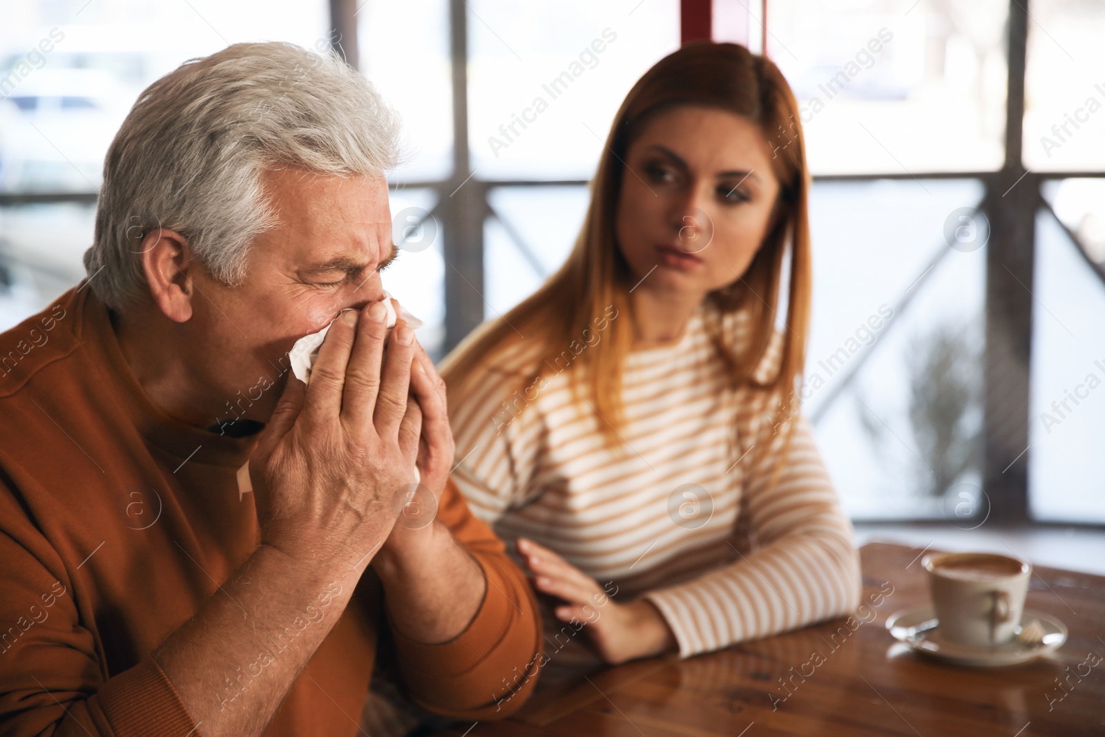 Photo of Sick senior man with tissue in cafe. Influenza virus