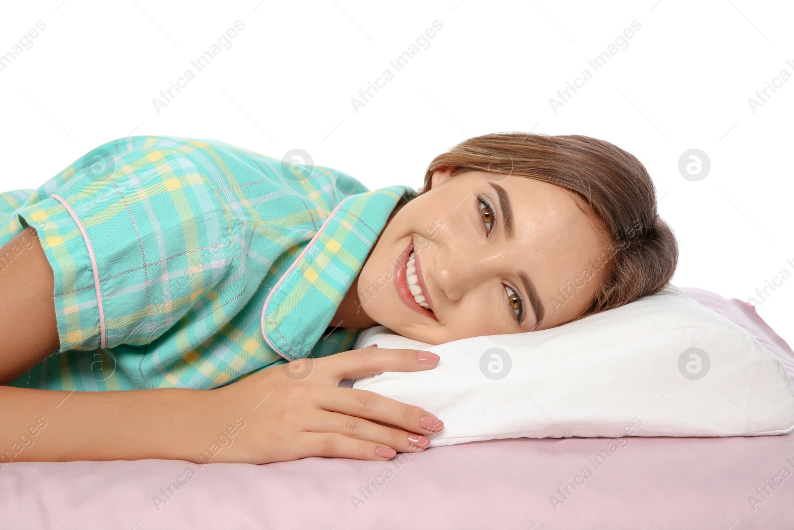 Photo of Beautiful teen girl lying with orthopedic pillow on bed against white background