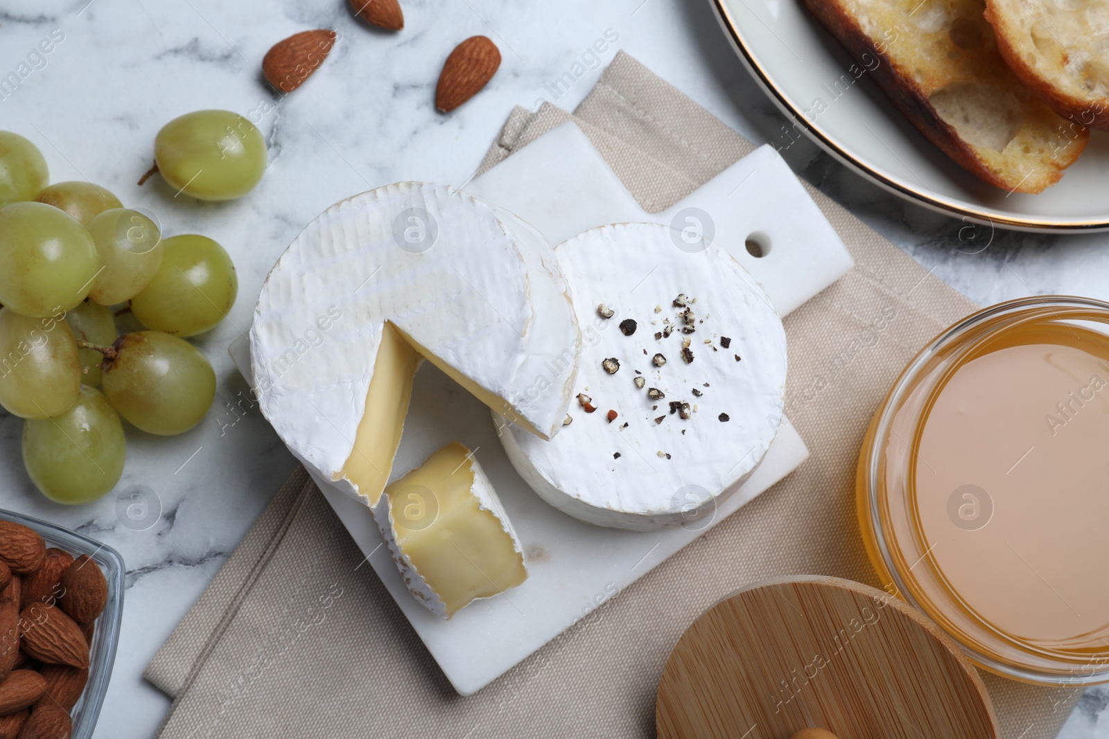 Photo of Flat lay composition with tasty brie cheese on white marble table
