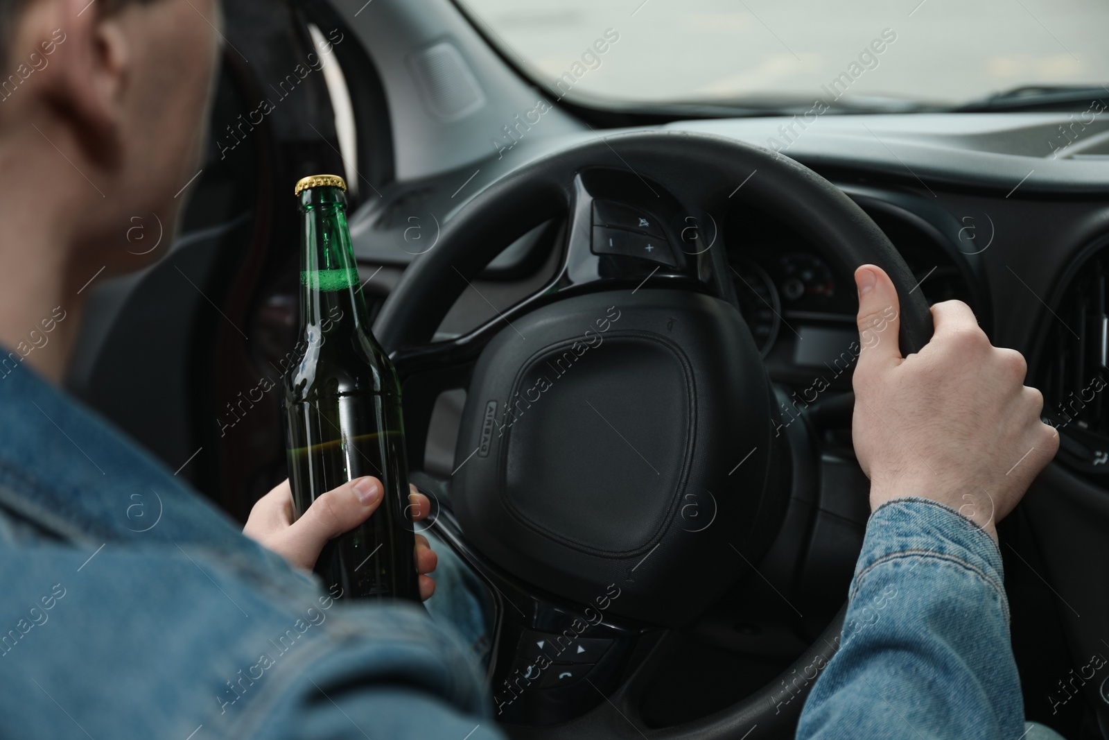 Photo of Man with bottle of beer driving car, closeup. Don't drink and drive concept