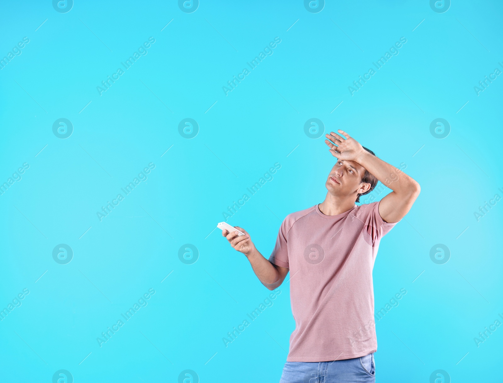 Photo of Young man suffering from heat on color background with copy space text. Air conditioner malfunction