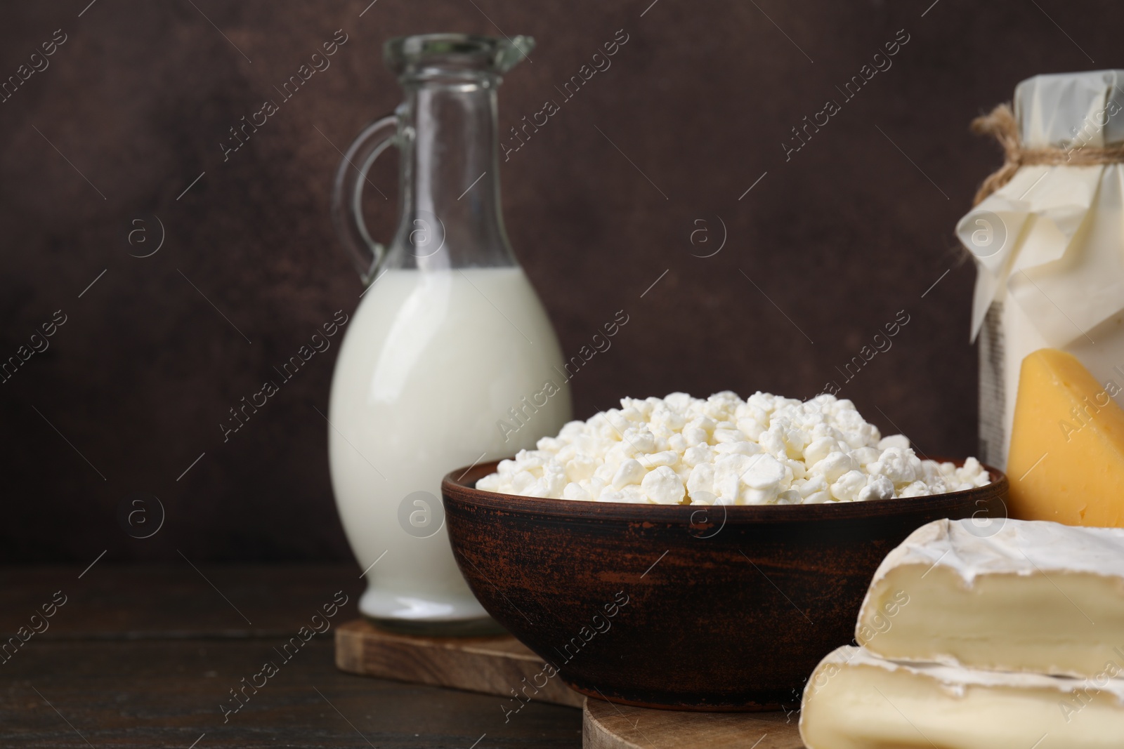 Photo of Dairy products. Different kinds of cheese and milk on wooden table, closeup. Space for text