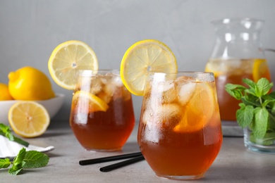 Photo of Delicious iced tea with lemon on grey table