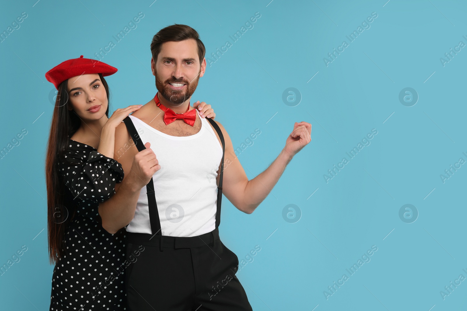 Photo of Beautiful couple posing together on light blue background, space for text