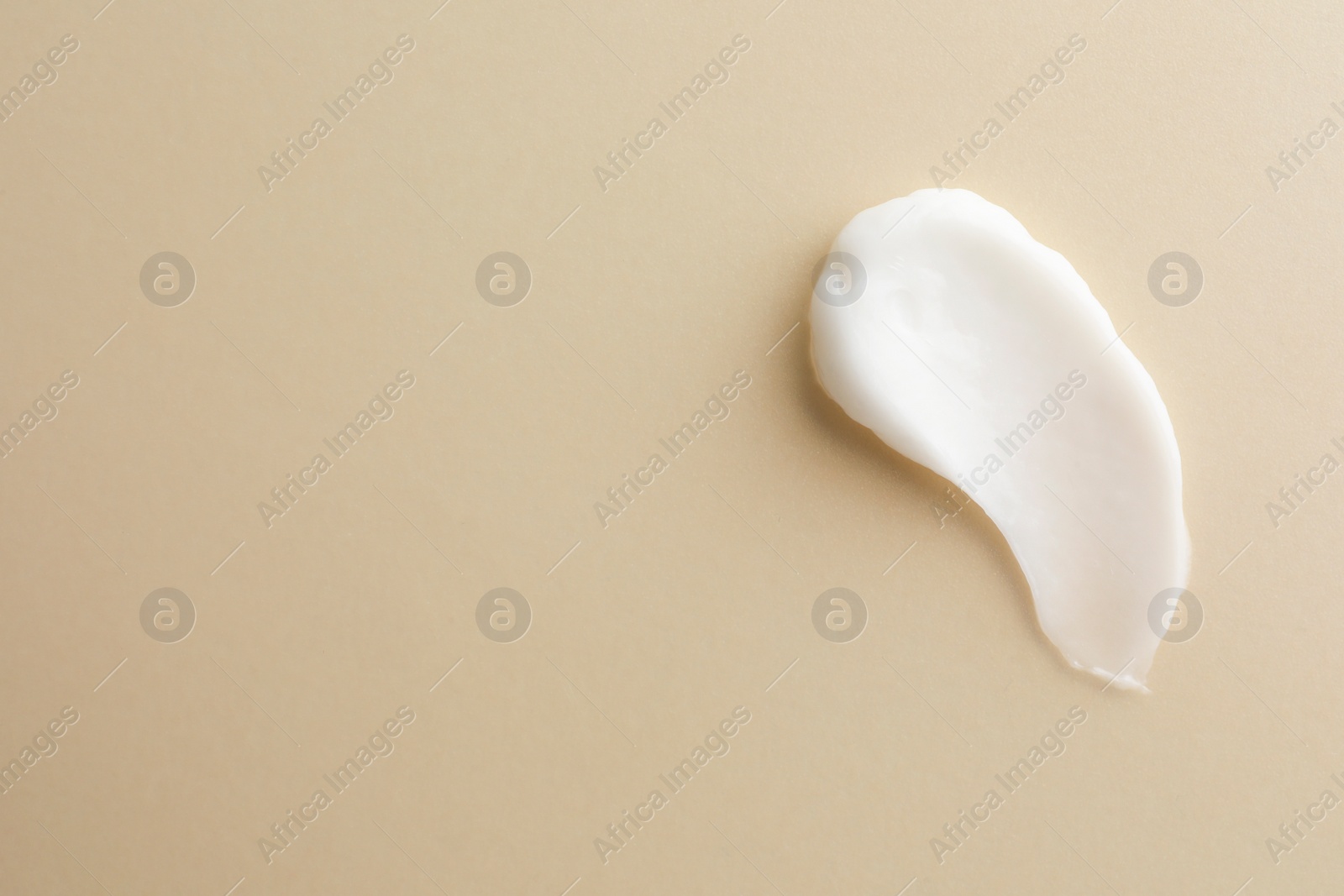 Photo of Sample facial cream on beige background, top view. Space for text