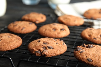 Photo of Cooling rack with chocolate chip cookies on wooden background