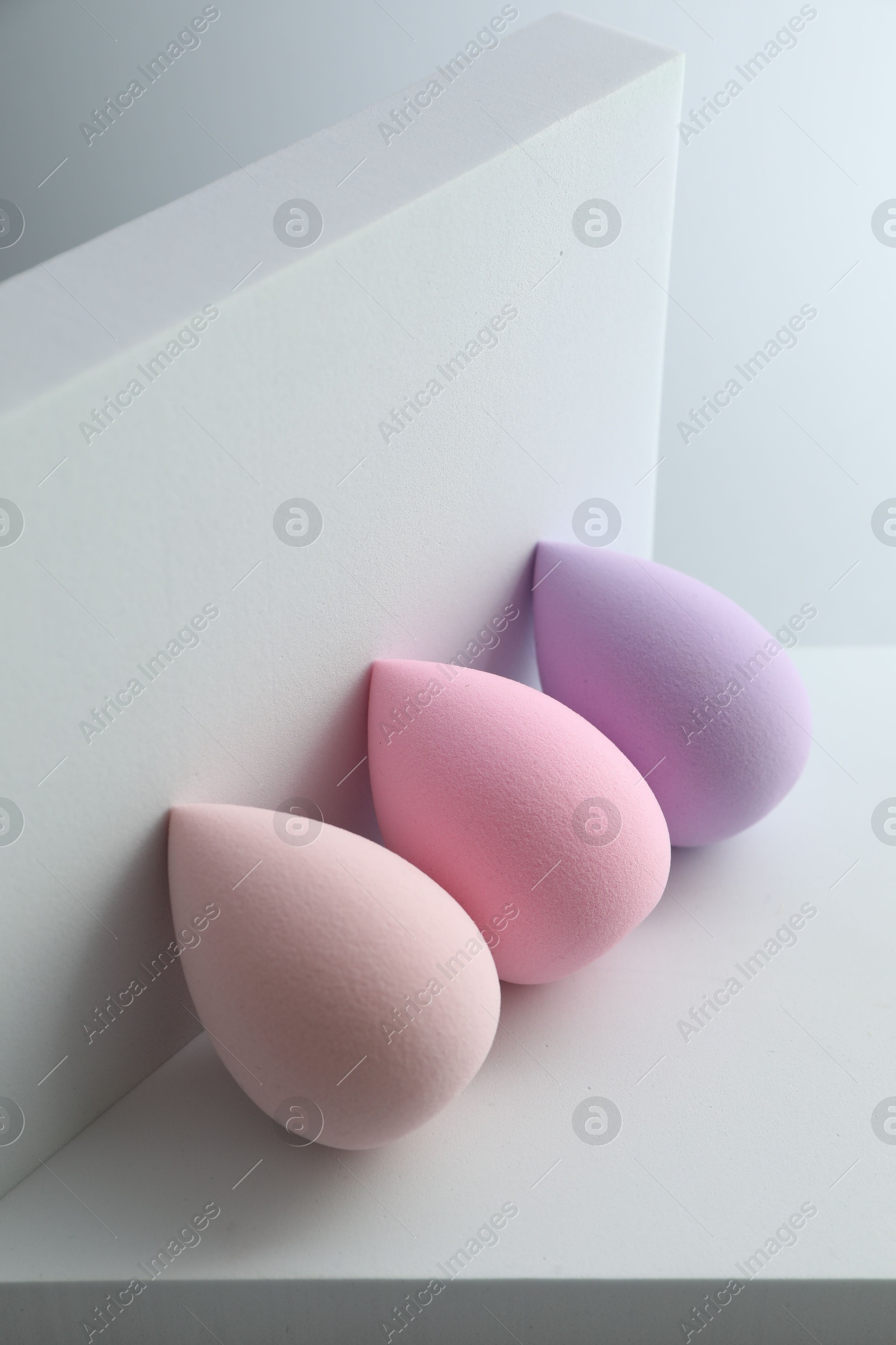 Photo of Stylish presentation of makeup sponges on light grey background