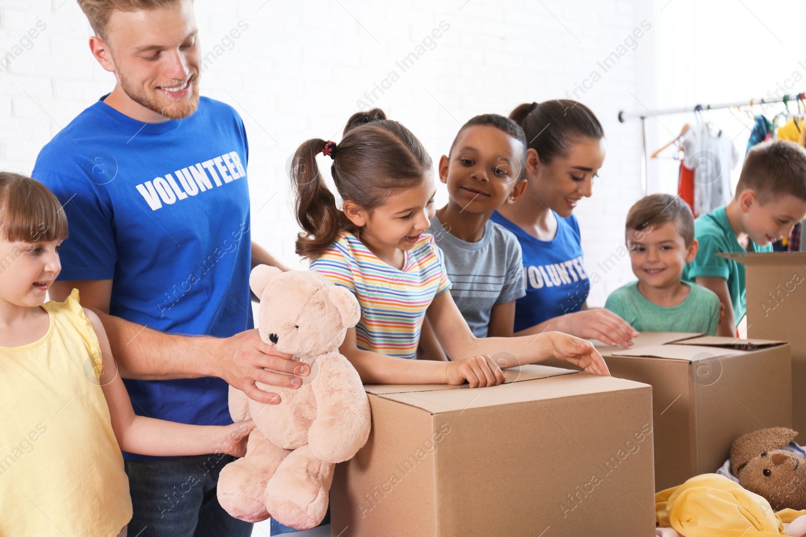 Photo of Volunteers with children sorting donation goods indoors
