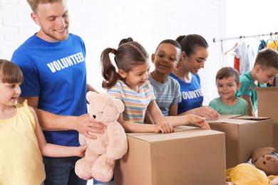 Volunteers with children sorting donation goods indoors