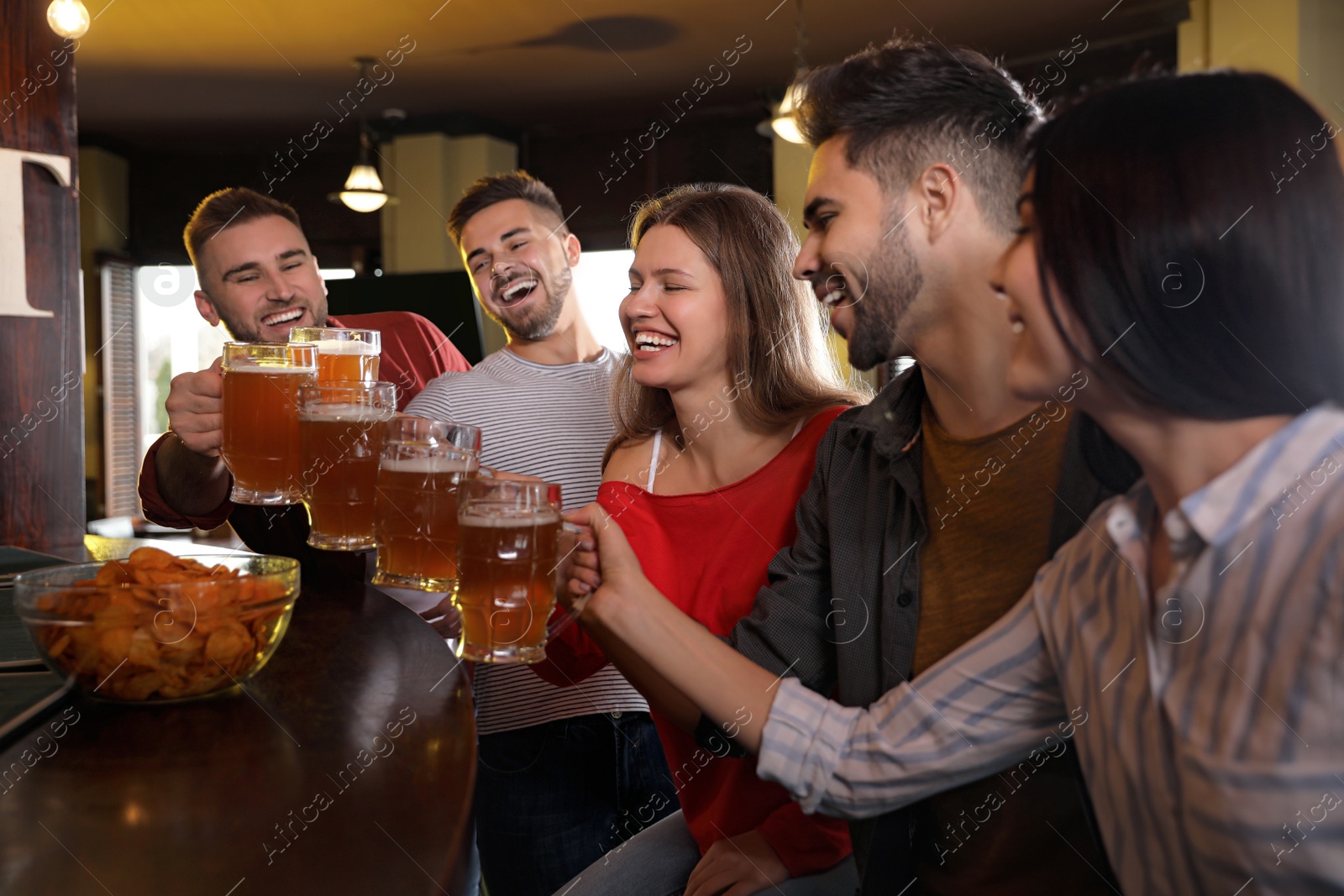 Photo of Group of friends celebrating victory of favorite football team in sport bar